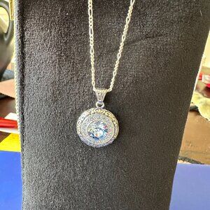 sterling silver round with scroll design and light blue crystal necklace
